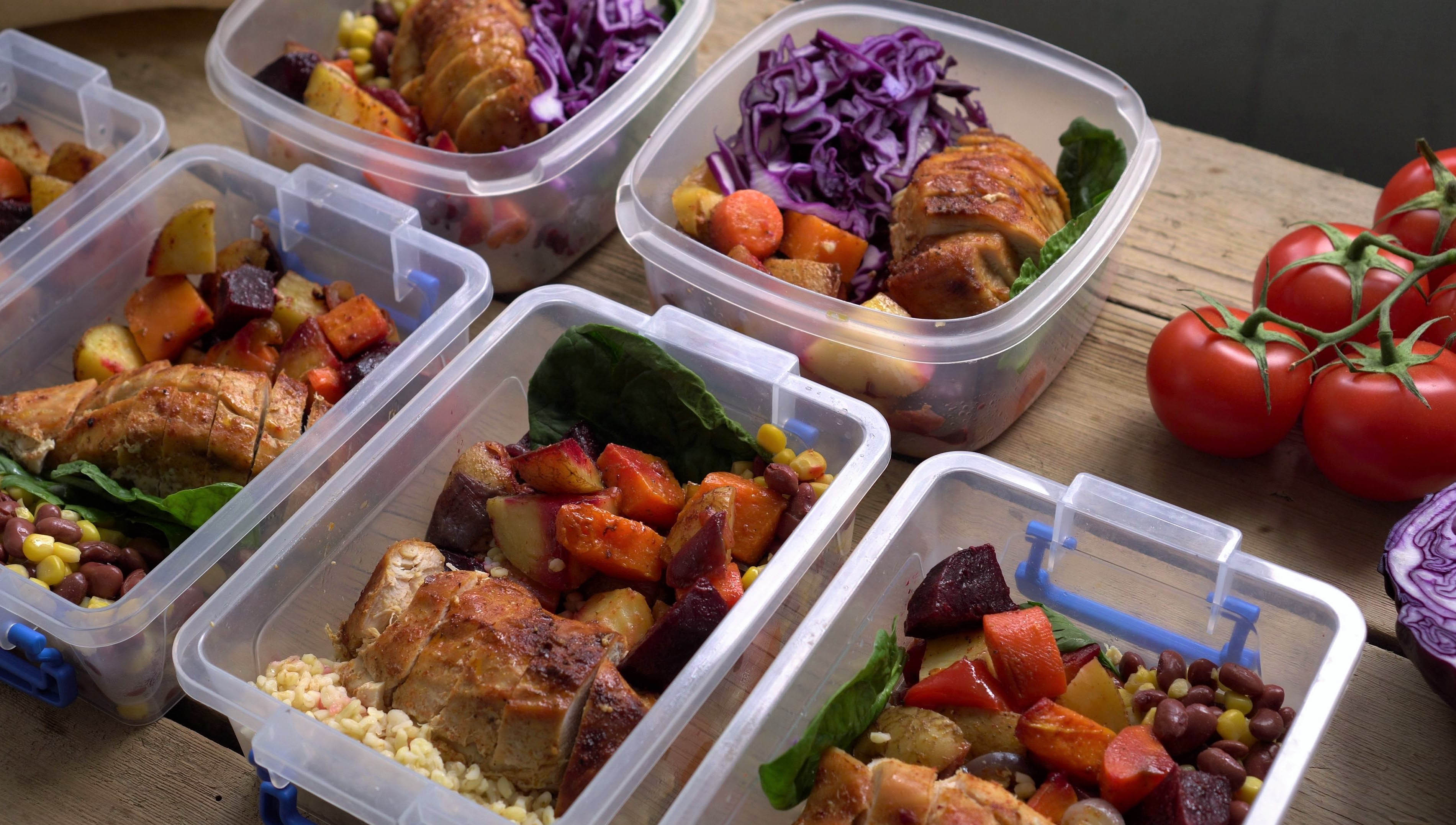 Multiple contains of meal prep that includes chicken, corn, beans, potatoes, and vegetables